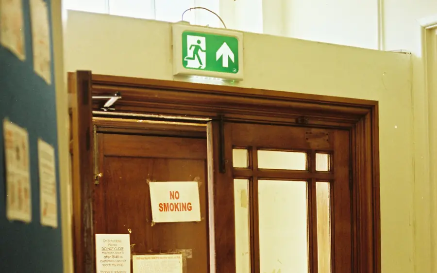 A timber door under a green fire exit sign