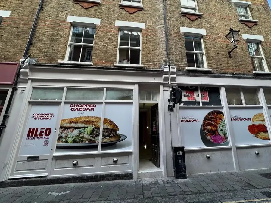 The shopfront and upper floors of an existing brick building in a London street